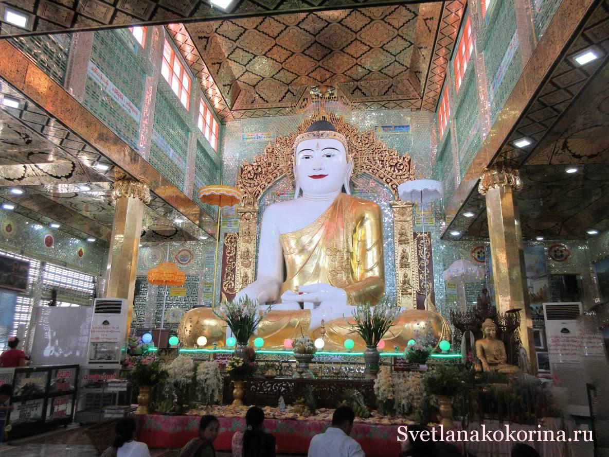 Белая статуя Будды на изумрудном фоне